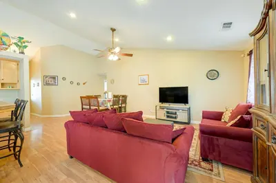 a living room with red couches and a flat screen tv at Porterville Getaway with Patio and Valley Views! in Porterville