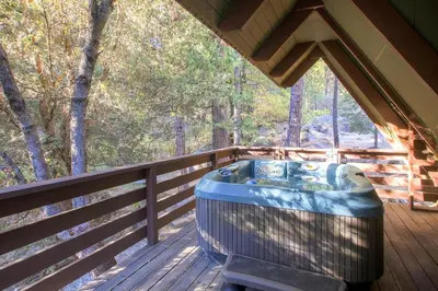 a jacuzzi tub sitting on a wooden deck at Yosemite's Creekside Birdhouse in Wawona