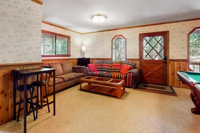a living room with a couch and a pool table at Cresta Cabin in Arnold
