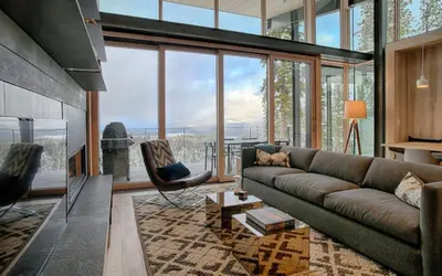 a living room with a couch and a large window at Modern Ski In-Out Home, Mid-Mountain in Truckee