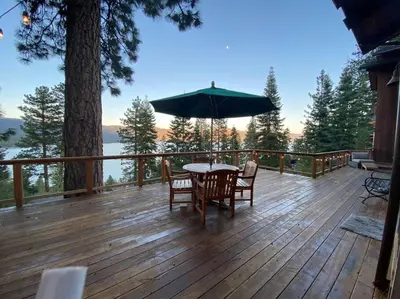a wooden deck with a table and chairs and an umbrella at Crystal Bay Lakeview in Crystal Bay