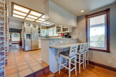 a kitchen with a counter and some stools at Meadow Vista Mountain Escape with River Views! in Meadow Vista
