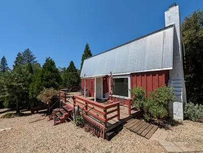 a building with a red barn with a porch at Moore's Cabin in Miramonte
