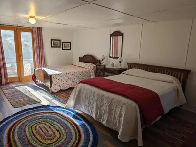 a bedroom with two beds and a table and a window at Moore's Cabin in Miramonte