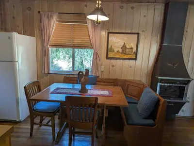 a kitchen with a table and chairs and a refrigerator at Moore's Cabin in Miramonte