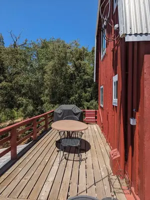 a wooden deck with a table and chairs on a building at Moore's Cabin in Miramonte