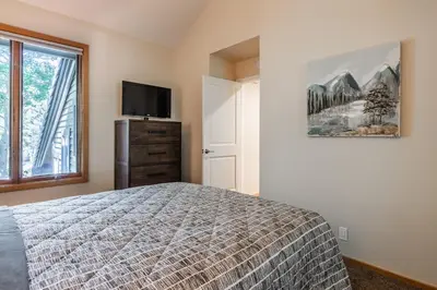 a bedroom with a bed and a flat screen tv at Updated 2 Bedroom Plus Loft 3 Bathroom Snowcreek Phase V #860 Sleeps 6 in Mammoth Lakes