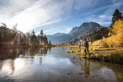 a man is standing on the shore of a river at Village Monache #720 condo in Mammoth Lakes