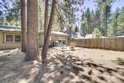 a backyard with a house and a fence and trees at half Mi to Lake Tahoe Pet-Friendly Cabin in South Lake Tahoe