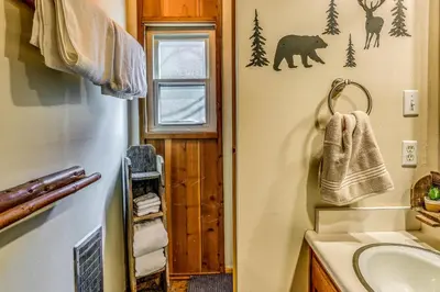 a bathroom with a sink and a bear on the wall at 3 Mi to Shaver Lake Cozy Bears Hideaway Cabin! in Shaver Lake