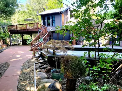 a house with a deck and a yard with a house at Magical River House ! 10 min to SNP park entrance in Three Rivers