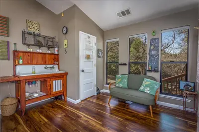 a living room with a couch and a sink and windows at Magical River House ! 10 min to SNP park entrance in Three Rivers