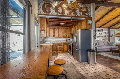 a kitchen with a stainless steel refrigerator and wooden cabinets at Magical River House ! 10 min to SNP park entrance in Three Rivers