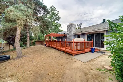 a house with a large deck on a yard at Pet-Friendly Home with Hot Tub! 6 Mi to Dtwn Reno in Reno
