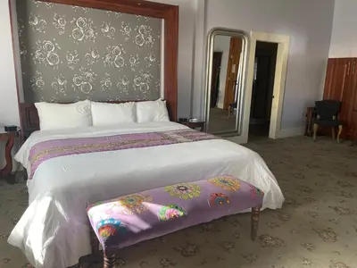 a bedroom with a large bed with a purple blanket at Hotel Sutter in Sutter Creek