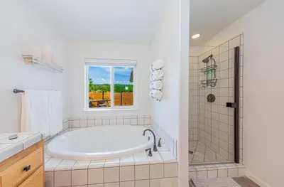 a white bathroom with a tub and a window at Hidden Falls Retreat Peaceful Guesthouse Near Yosemite in Oakhurst