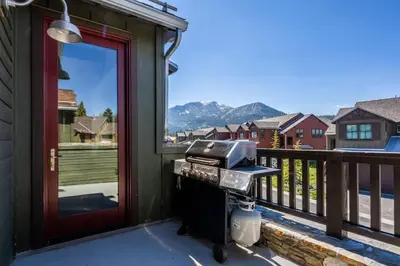 a grill on a balcony with a view of the mountains at Creekhouse 1342 in Mammoth Lakes