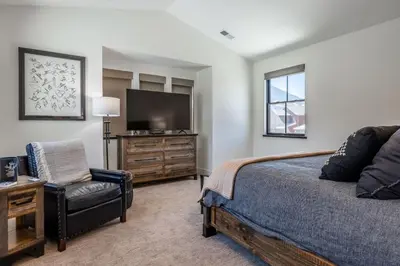 a bedroom with a bed and a chair and a television at Creekhouse 1342 in Mammoth Lakes
