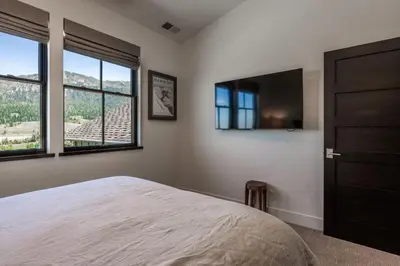 a bedroom with a bed and a flat screen tv at Creekhouse 1342 in Mammoth Lakes