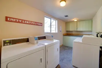 a kitchen with white cabinets and a sign on the wall at Mammoth Lakes Condo with Fireplace and Mountain Views in Mammoth Lakes