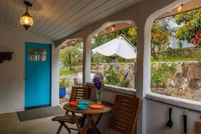 a porch with a table and chairs and a blue door at The Haven -In Town, NEWLY remodeled, Private, Stocked in Mariposa