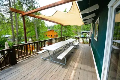 a wooden deck with a picnic bench on it at Johnson Lake FrontReduced Nightly Rates in Bass Lake