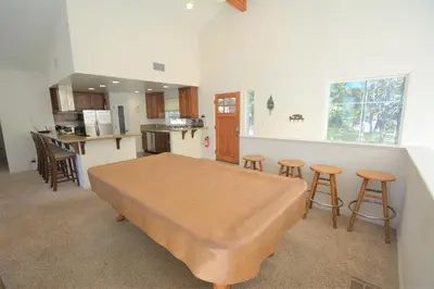 a room with a bed and a kitchen with stools at Lake Shore Lake Front Free Night Special in Bass Lake