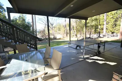 a screened porch with a ping pong table and chairs at Lake Shore Lake Front Free Night Special in Bass Lake