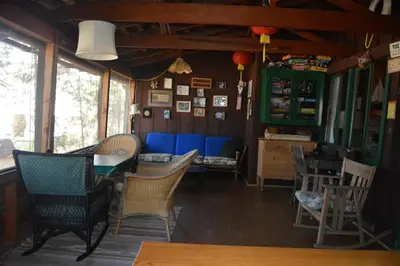 a dining room with chairs and a table and blue couch at Charming 1927 Lake Front Home - Hargrave in Bass Lake