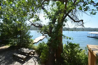 a picnic table and a bench next to a lake at Dupzyk Lake Front Reduced Nightly Rate in Bass Lake