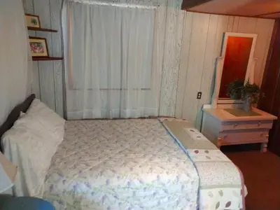a bedroom with a bed and a dresser and a window at Idylwild-Lake Area in Bass Lake