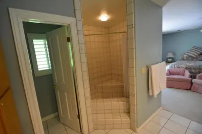 a bathroom with a walk in shower next to a bed at King- Lake Area in Bass Lake