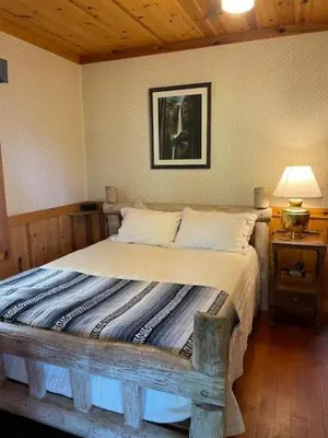 a bedroom with a bed with a picture on the wall at O'Connell-Lake Area Free Night Special in Bass Lake