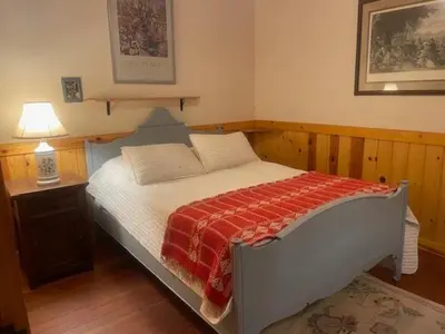 a bedroom with a large bed with a red blanket at O'Connell-Lake Area Free Night Special in Bass Lake