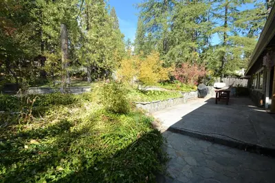 a walkway in a garden with a table and trees at O'Connell-Lake Area Free Night Special in Bass Lake