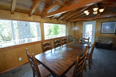 a dining room with a large wooden table and chairs at O'Hara Lake View in Bass Lake