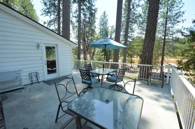 a patio with tables and chairs and an umbrella at O'Hara Lake View in Bass Lake