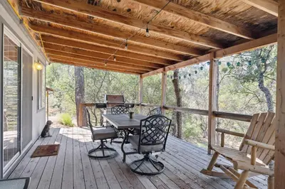 a screened porch with a table and chairs on it at Newly Renovated Retreat on 6 Acres, Discover Murphys Lodge with Scenic Views! in Murphys