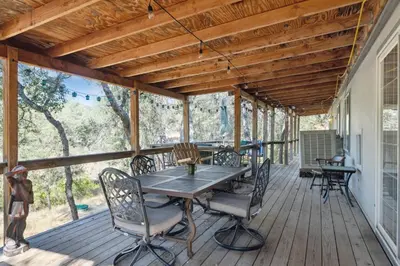 a wooden deck with a table and chairs on it at Newly Renovated Retreat on 6 Acres, Discover Murphys Lodge with Scenic Views! in Murphys