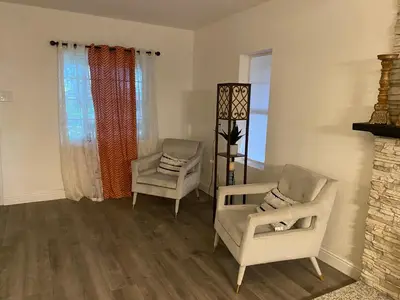 a living room with two chairs and a fireplace at Entire cozy home in Madera