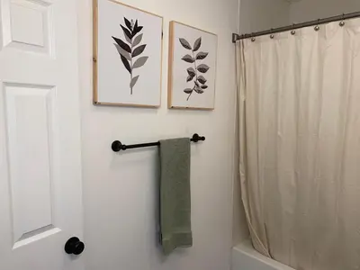 a bathroom with a shower curtain and a green towel at Entire cozy home in Madera