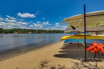 a group of umbrellas on a beach next to the water at The Lake Haus in Groveland