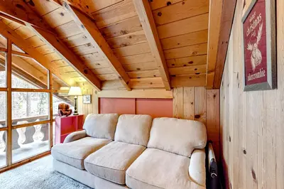 a living room with a couch in a room with wooden ceilings at Pine Knolls in Tahoma
