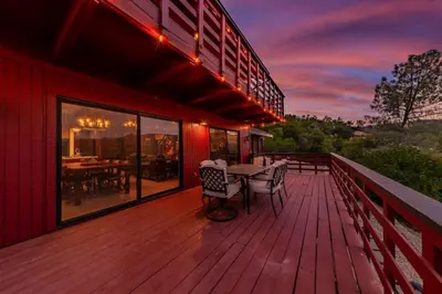 a wooden deck with a table and chairs on it at Yosemite Cowboy Cabin in Oakhurst