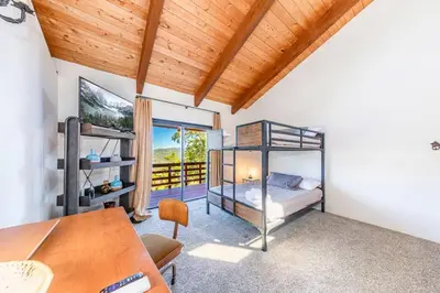 a bedroom with a bunk bed and a table at Yosemite Cowboy Cabin in Oakhurst
