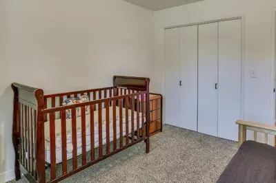 a crib in a room with a closet and a bedroom at Pet-Friendly Coarsegold Vacation Rental with Deck! in Coarsegold