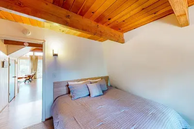a bedroom with a bed with blue pillows on it at Cozy Cabin in Groveland
