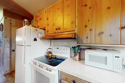 a kitchen with white appliances and wooden cabinets at Fernwood in Shaver Lake
