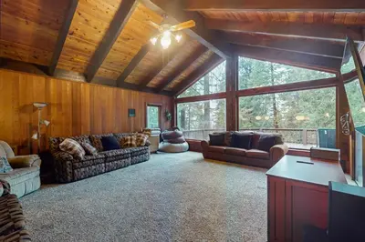 a living room with couches and a large window at Tranquil Pines Estate in Shaver Lake