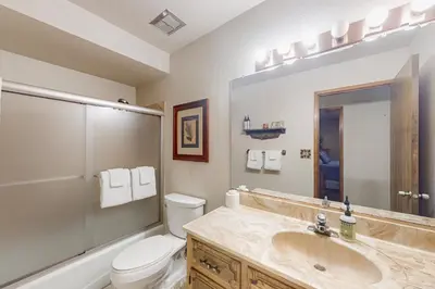 a bathroom with a sink and a toilet and a mirror at Tranquil Pines Estate in Shaver Lake